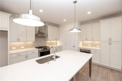 You can utilize the large quartz island for meal prep while visiting with family and guests.   Pictures represent a previously built home, not the actual home.