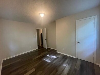 Unfurnished bedroom with a textured ceiling and da