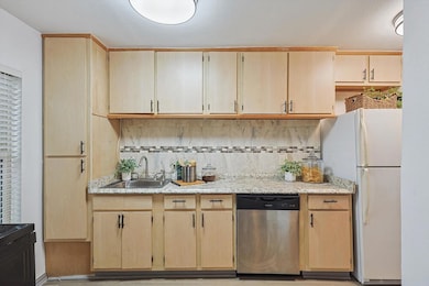 Kitchen with stainless steel dishwasher, white fri