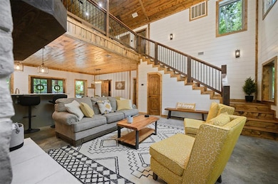 Living room with wood walls, wooden ceiling, high 