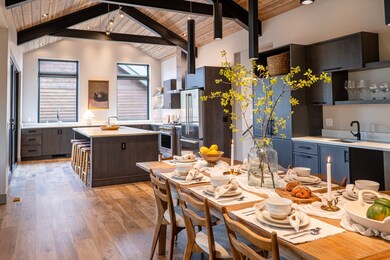 Dining area featuring lofted ceiling with beams, wood ceiling, and light wood finished floors