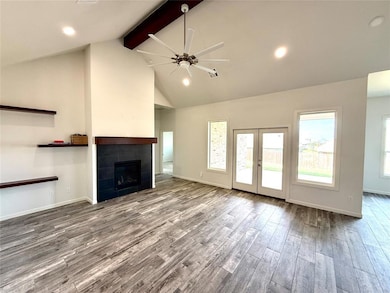 Unfurnished living room with a ceiling fan, recessed lighting, beamed ceiling, french doors, and wood finished floors