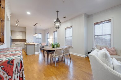 Dining room with crown molding, sink, light hardwo