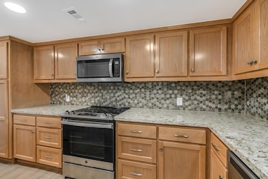Kitchen featuring stainless steel appliances, bac
