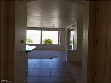 Entryway with arched walkways, baseboards, tile pa