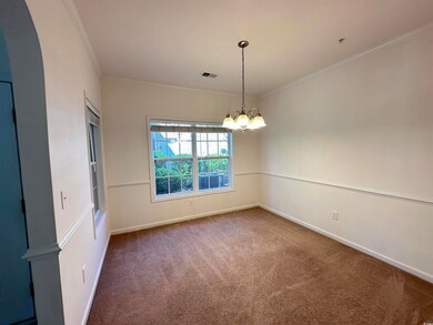 Spare room with carpet, visible vents, arched walk