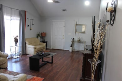 Living room featuring dark wood finished floors, vaulted ceiling, a ceiling fan, and recessed lighting