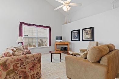 Living room featuring baseboards, high vaulted cei