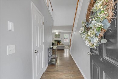 Entryway with baseboards, a lit fireplace, and woo