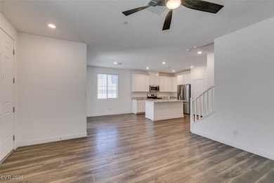 Unfurnished living room featuring baseboards, wood finished floors, recessed lighting, and a ceiling fan