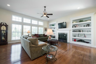 The great room has 11 ft ceilings, a wall of windows, gas fireplace and built-in bookshelves!