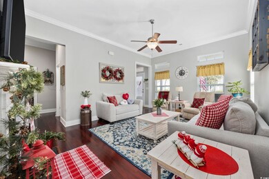 Living room featuring crown molding, ceiling fan, 