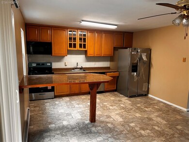 Kitchen featuring dark countertops, tasteful backsplash, brown cabinets, and stove