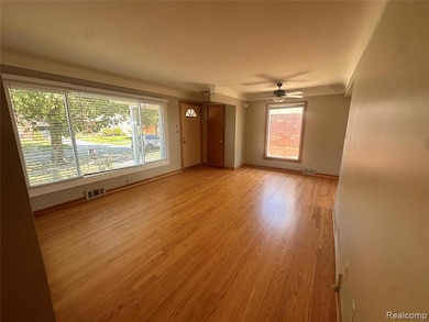 Unfurnished living room featuring light wood-type flooring and a ceiling fan