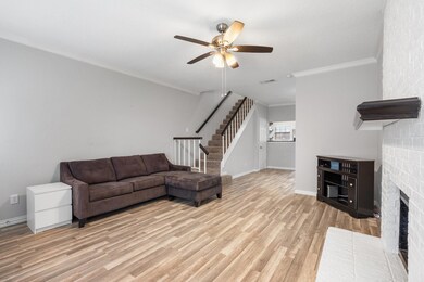 Living room featuring crown molding, ceiling fan, 
