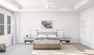 Primary suite with decorative feature wall and tray ceiling with crown moulding