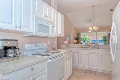 Kitchen with white cabinets, white appliances, lof