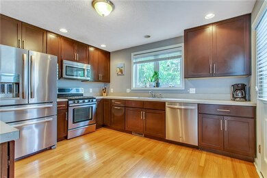 The kitchen features stainless appliances and plen