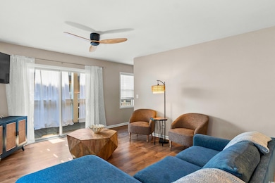Living area featuring a ceiling fan, baseboards, a