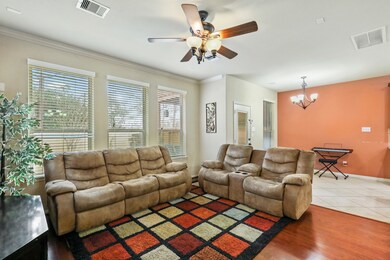 Lovely Living Room offers wonderful wood flooring, wall of windows, and crown molding making this space a wonderful area for family time.