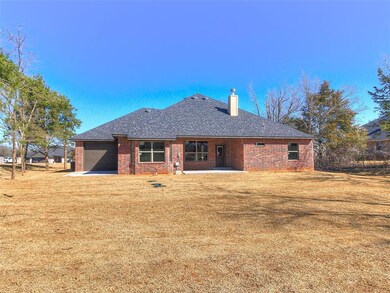 Rear view of property with brick siding, a shingle