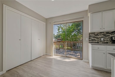 Unfurnished dining area featuring light wood-style floors and baseboards