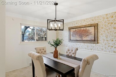 Dining area featuring light carpet, wallpapered walls, and a chandelier