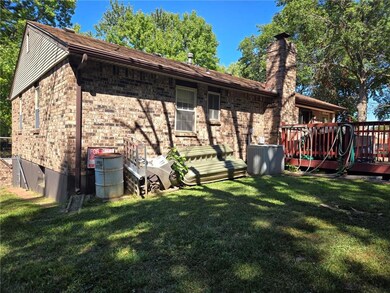 View of side of property with central AC unit, a yard, and a wooden deck
