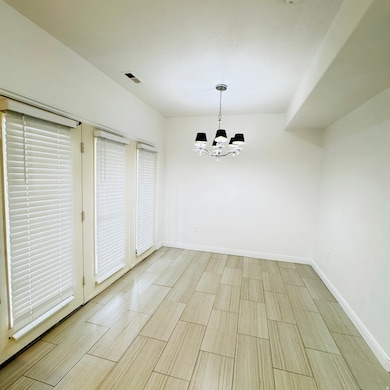 Unfurnished dining area featuring a chandelier and wood tiled floors