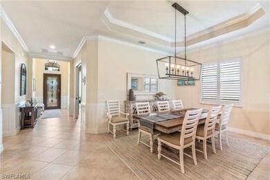 Tiled dining space featuring a tray ceiling, crown