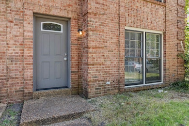 Entrance to property featuring brick siding