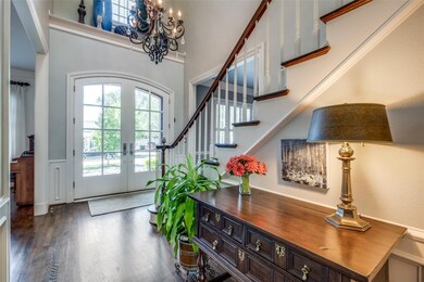 Foyer featuring a chandelier, crown molding, dark 