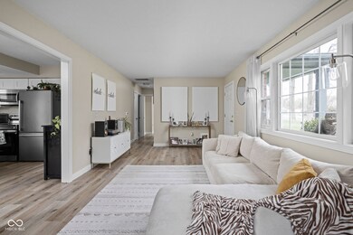 living room with light wood finished floors, baseboards, and visible vents