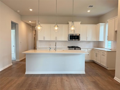 Kitchen featuring stainless steel microwave, back