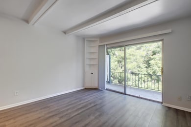 Spare room featuring beamed ceiling and dark wood
