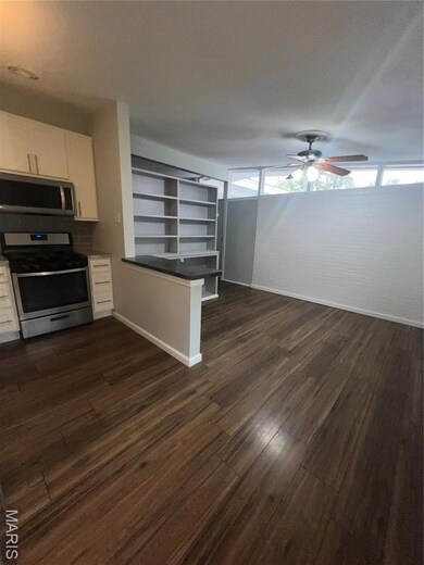 Kitchen featuring range, white cabinets, dark wood-style floors, a ceiling fan, and open floor plan