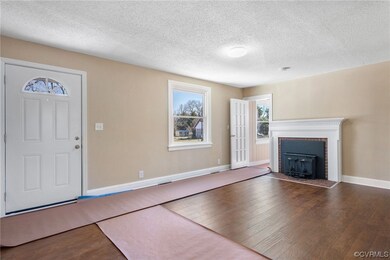 Unfurnished living room with a fireplace, dark hardwood / wood-style flooring, and a textured ceiling