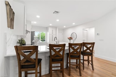 Kitchen with a breakfast bar, sink, light hardwood