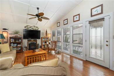 The living room features tall ceilings, gleaming h