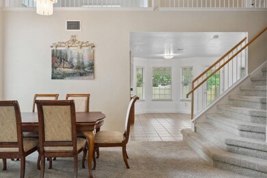 Carpeted dining area featuring stairs, tile patte