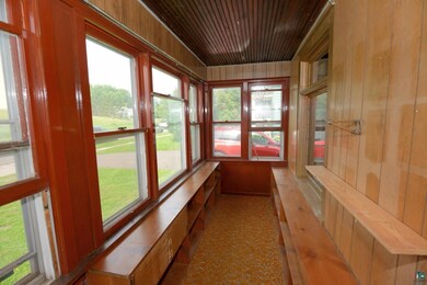 Unfurnished sunroom with wood ceiling and book cas