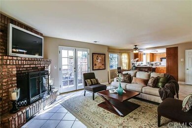 Family room with a brick fireplace and the dining 