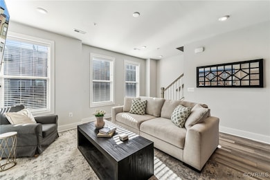 Living area featuring stairway, visible vents, bas