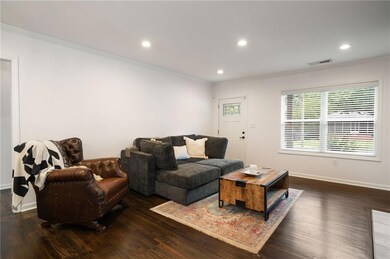 Living area with ornamental molding, baseboards, recessed lighting, and wood finished floors