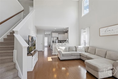 Soaring ceilings and floor to ceiling windows allow natural light to pour into this family room.