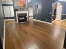 Living room featuring wood finished floors, a fireplace, baseboards, and arched walkways