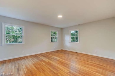 A few steps from the main level you will find the bedrooms, including this primary, with lots of windows and beautiful hardwood floors.