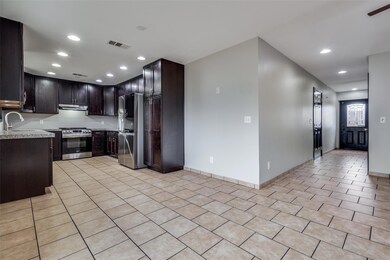Kitchen with stainless steel fridge, stove, dark b