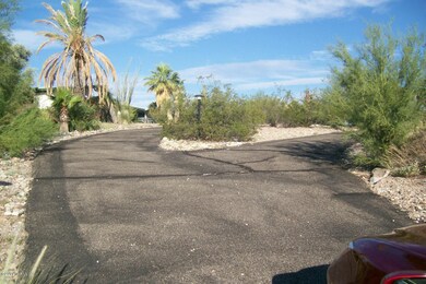 Circular asphalt drive leading to house.