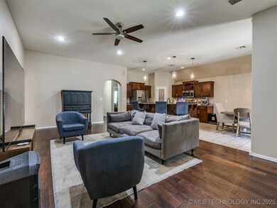 Living area with ceiling fan, arched walkways, rec
